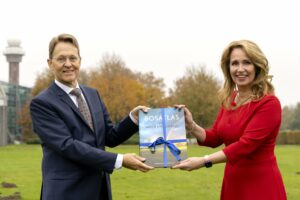Helga van Leur neemt eerste exemplaar van De Bosatlas van weer en klimaat in ontvangst